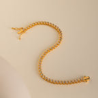 Diamond Bezel Tennis Bracelet featuring round white stones set in a graceful S shape on a beige background—an elegant, minimalist gemstone bracelet and an ideal personalized bridal gift.