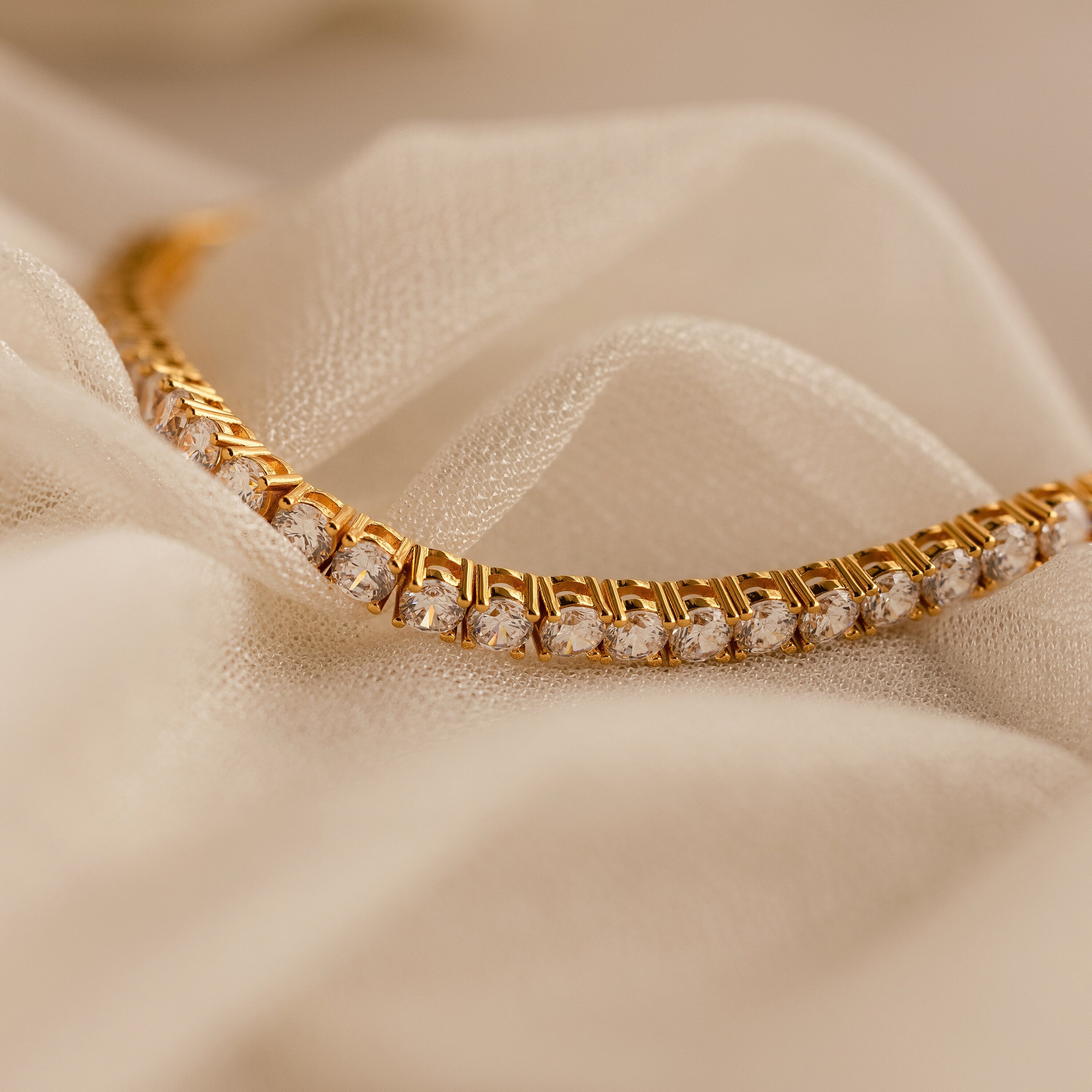 The Bold Diamond Tennis Bracelet rests on soft beige fabric—an eye-catching choice for bridesmaid jewelry or anyone wanting a bold diamond bracelet.