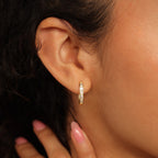 A close-up of a woman's ear adorned with elegant Baguette Link Hoops.