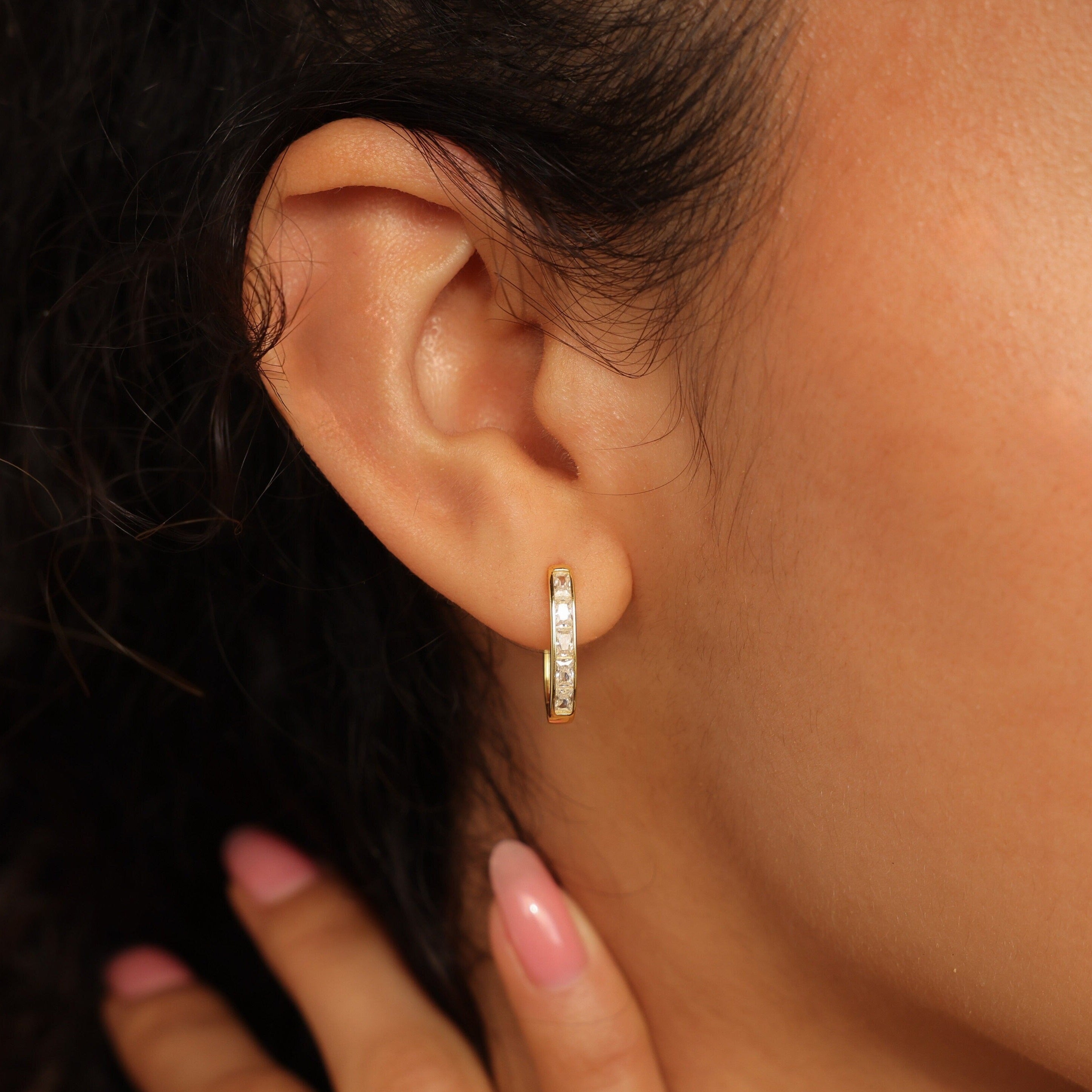 A close-up of a woman's ear adorned with elegant Baguette Link Hoops.