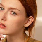 A woman with fair skin and red hair wears the Dainty Opal Stud Earrings Set, pairing multiple gold and opal studs for a minimalist jewelry look as she gazes at the camera.