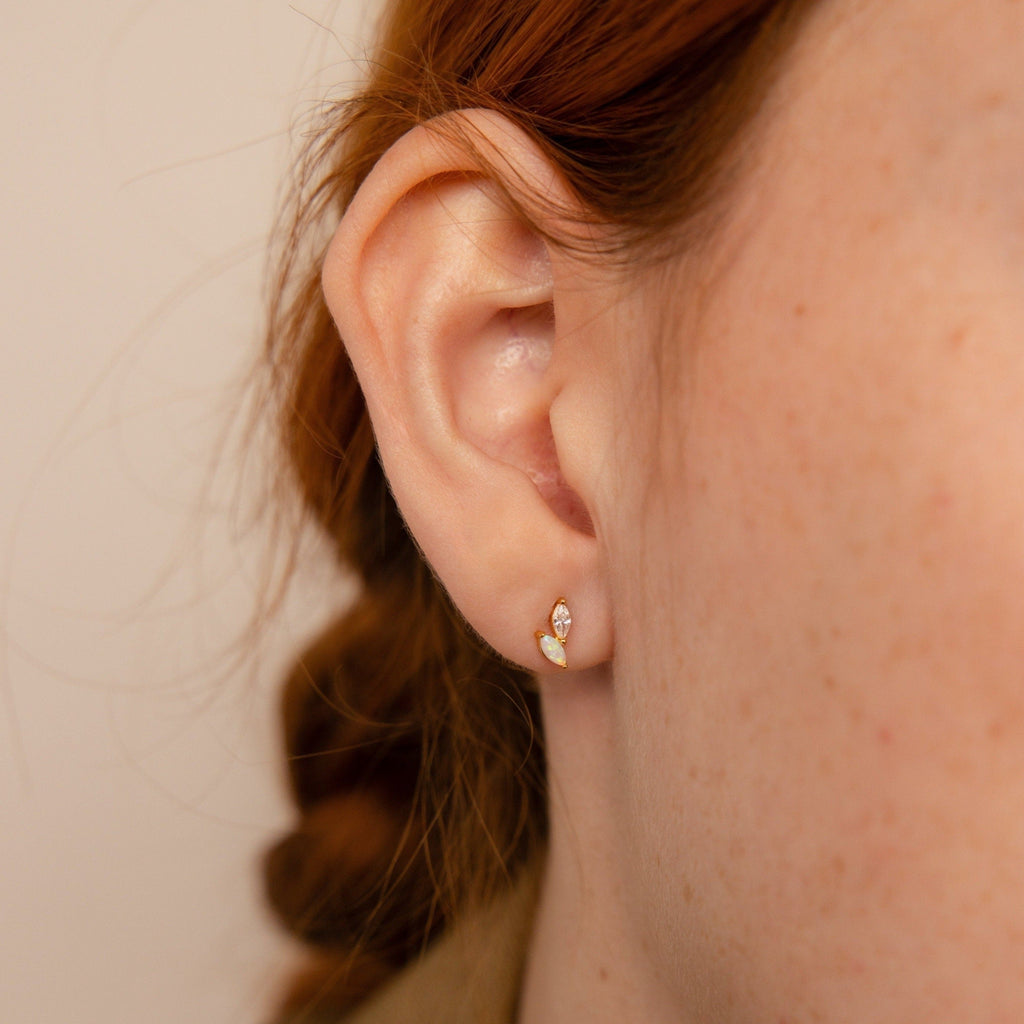 A close-up of a woman's ear wearing the Dainty Opal Stud Earrings Set, highlighting the elegant simplicity of minimalist jewelry.
