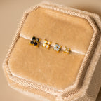 Four Opal Ivy Flower Studs with gold settings and colorful opal stones are displayed on a beige velvet jewelry box—an elegant, meaningful gift.