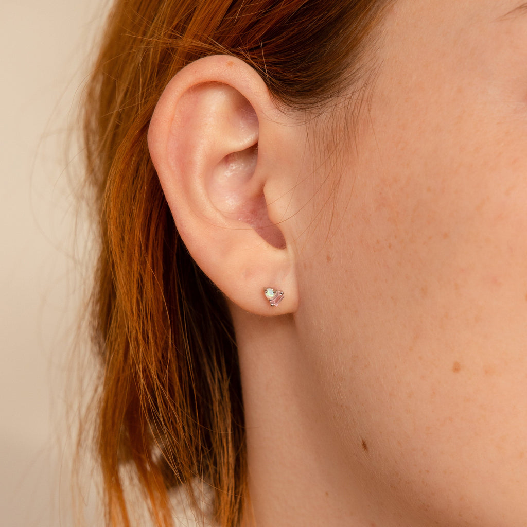 Close-up of a person's ear wearing Pink Baguette Opal Studs, set against light reddish-brown hair—an elegant choice for bridal gifts.