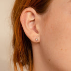 Close-up of a person's ear wearing Pink Baguette Opal Studs, set against light reddish-brown hair—an elegant choice for bridal gifts.