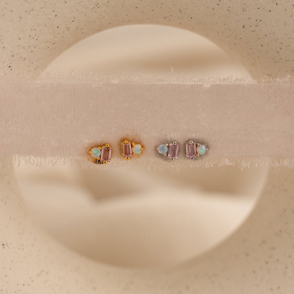 Pink Baguette Opal Studs and pink tourmaline earrings, shown on soft beige fabric, make elegant bridal gifts.