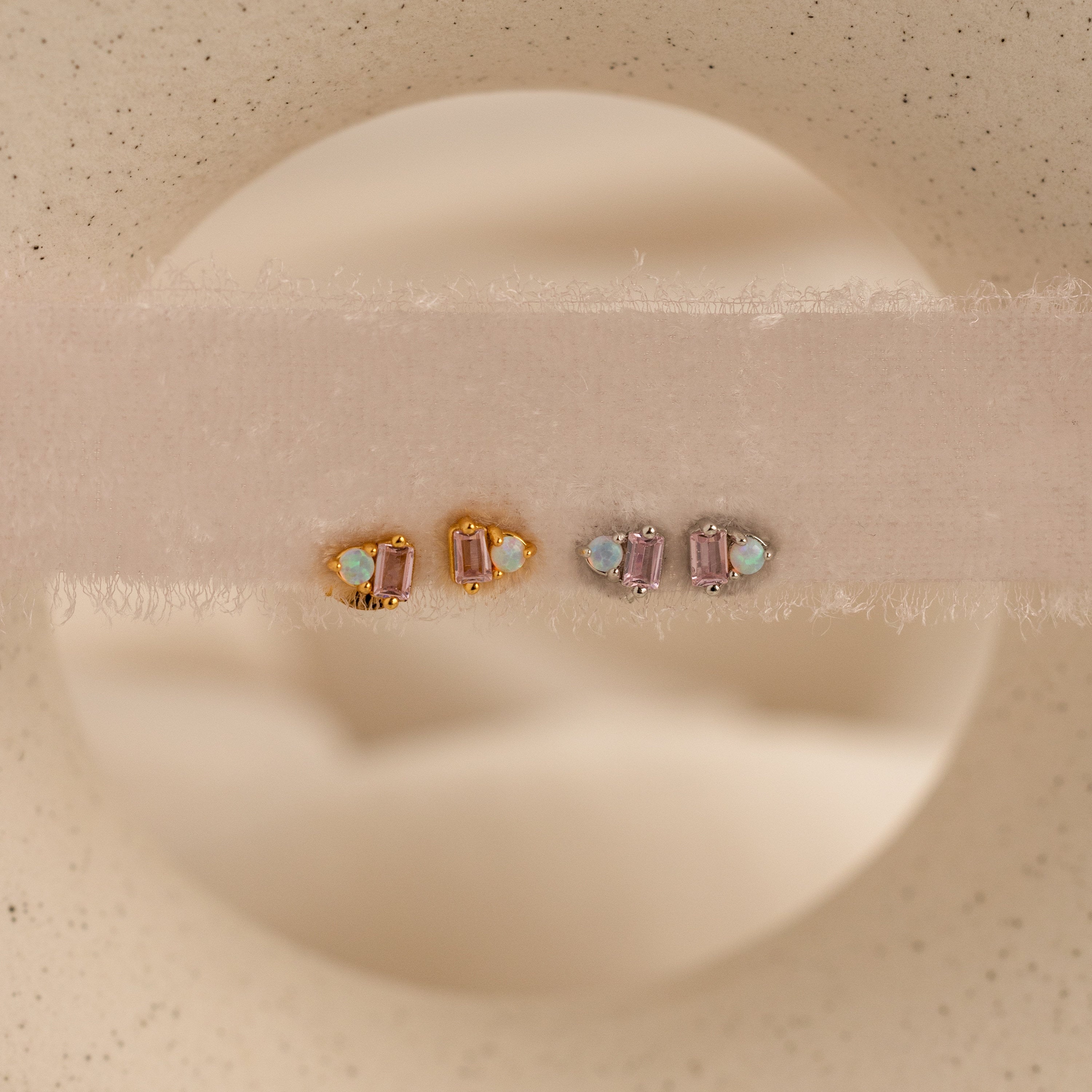 Pink Baguette Opal Studs and pink tourmaline earrings, shown on soft beige fabric, make elegant bridal gifts.