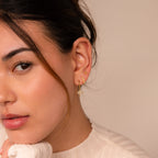 A woman with brown hair wears the Opal Starburst Earrings Set, looking at the camera with a neutral expression.