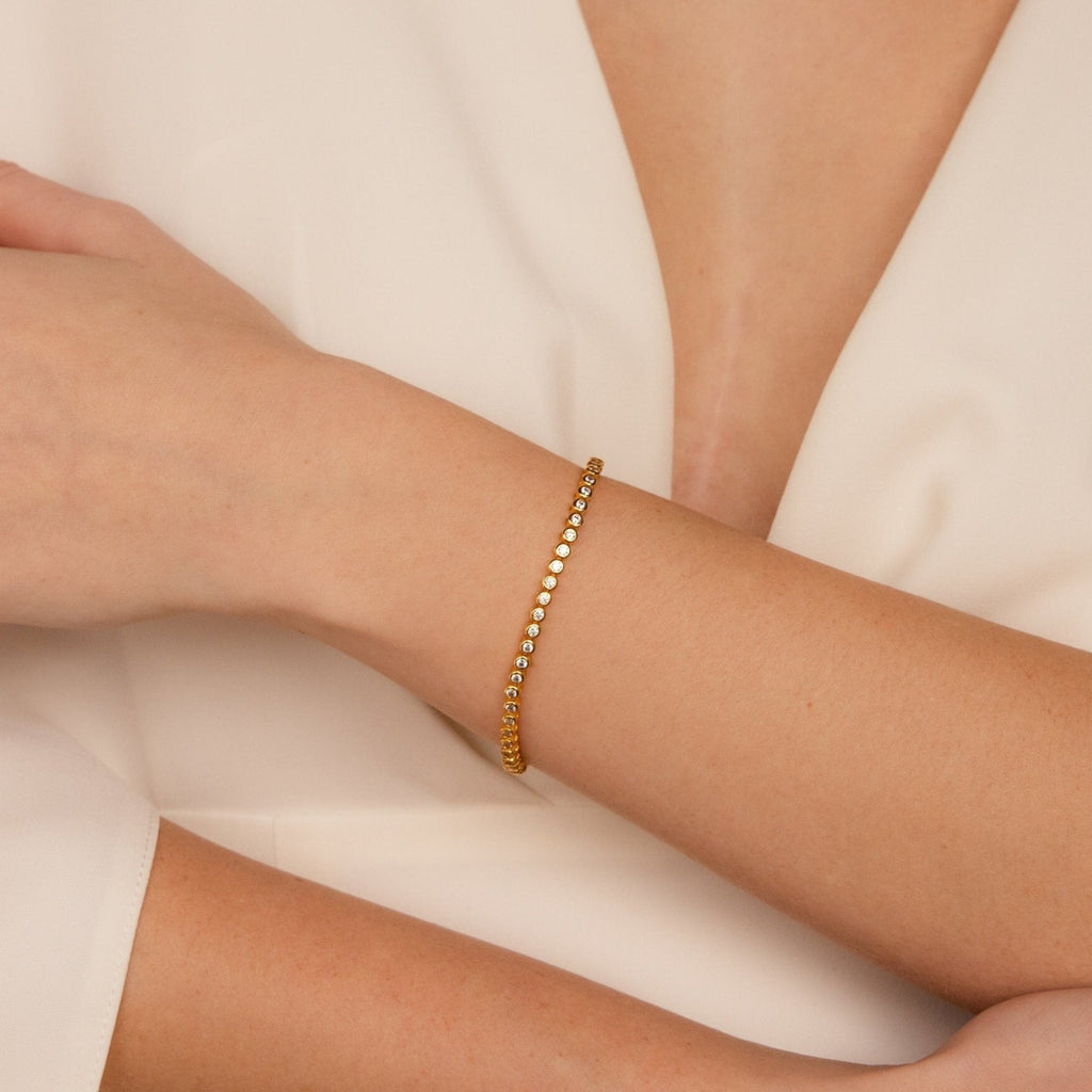 The Diamond Bezel Tennis Bracelet features small diamonds and adds minimalist elegance to any outfit, making it a perfect personalized bridal gift.