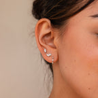 Close-up of a woman's ear adorned with the Marquise Diamond Earrings Set on a neutral background, capturing elegant wedding style—perfect inspiration for memorable bridesmaid gifts.