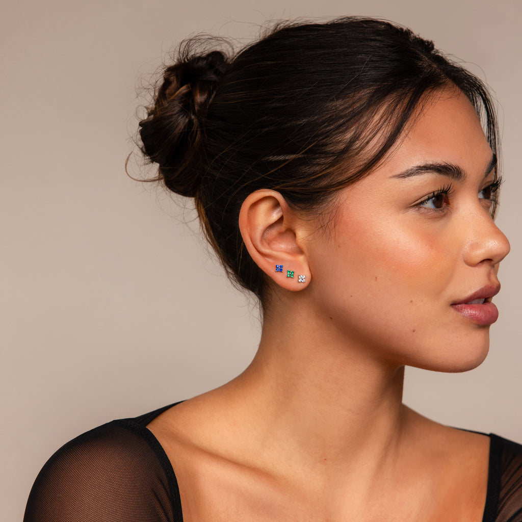 Woman with dark hair in a bun wears the Flower Flat Back Studs Set—small, colorful flower earrings—while facing right against a neutral background.