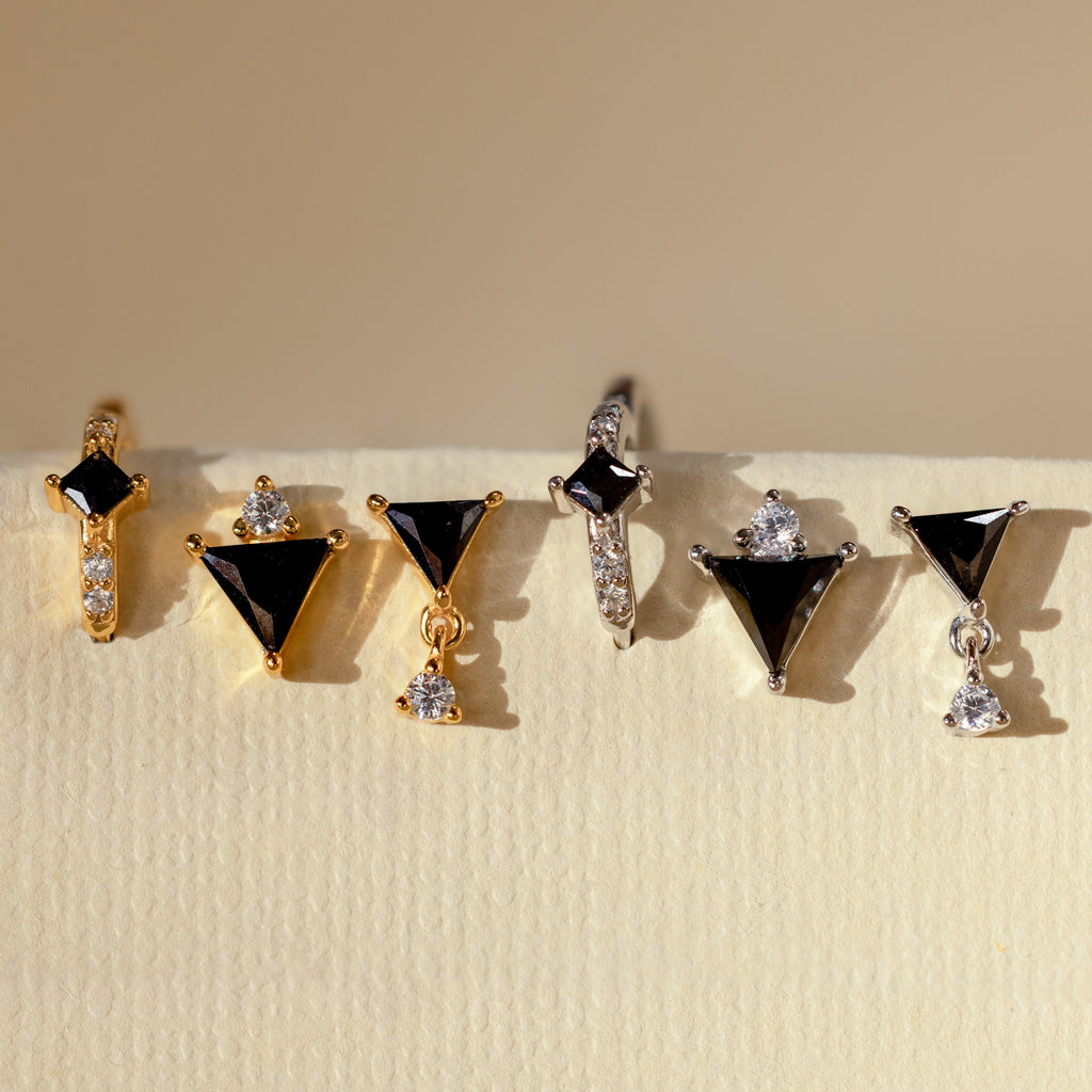 The Black Art Deco Earrings Set, designed for minimalism jewelry enthusiasts, features elegant black and clear gemstone accents and is beautifully displayed on a light textured surface.