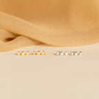 A row of opal earrings with small stones, featuring sparkling Opal Diamond Bar Studs.