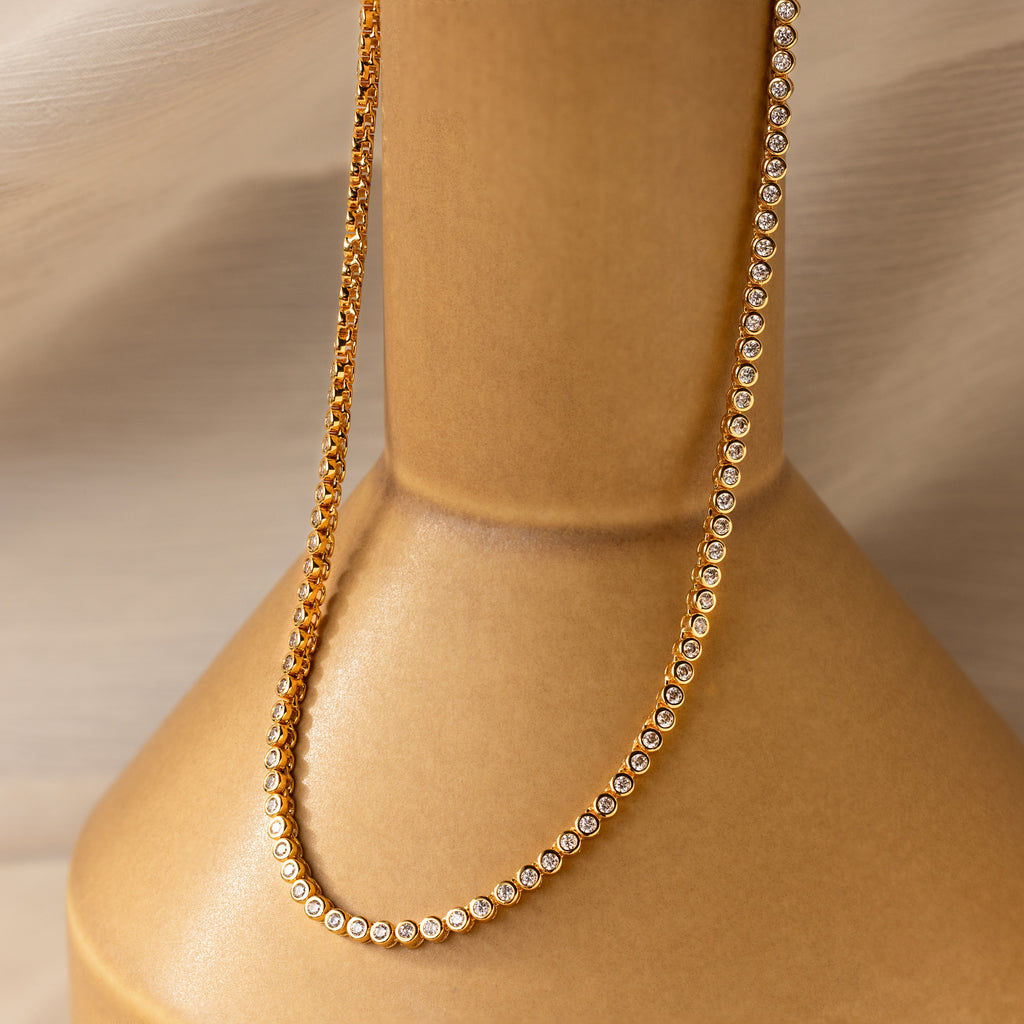 The Diamond Bezel Tennis Necklace with small round diamonds shines elegantly—a stunning bridal necklace and perfect gift for the bride.