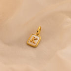 Gold Mother of Pearl Initial Charm with Letter K, featuring a rectangular pearl base with rounded gold corners, a large jump ring, and an initial in times new roman.