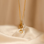 A Mother of Pearl Heart Charm in Sterling Silver necklace is displayed on smooth beige fabric, offering a touch of vintage-inspired elegance.