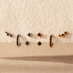 The Black Diamond Earrings Set features bold huggie hoops and climber studs, each adorned with striking black stones for a captivating look.