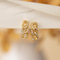 Pave Link Studs: Elegant gold and diamond chain-link earrings, beautifully showcased on a cream fabric background.