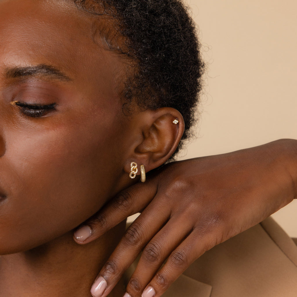 A close-up of a woman's face showcases her elegant earrings, with the Pave Link Studs adding a subtle sparkle.