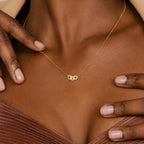 A woman wearing the Pave Link Necklace, a gold piece featuring a small interlocking links pendant that rests gently on her collarbone—a subtle highlight from the jewelry collection.