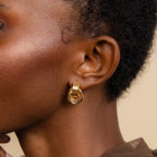 Close-up of a person wearing the Triple Knot Earrings—gold hoops with a textured knot design, making them an elegant anniversary gift.