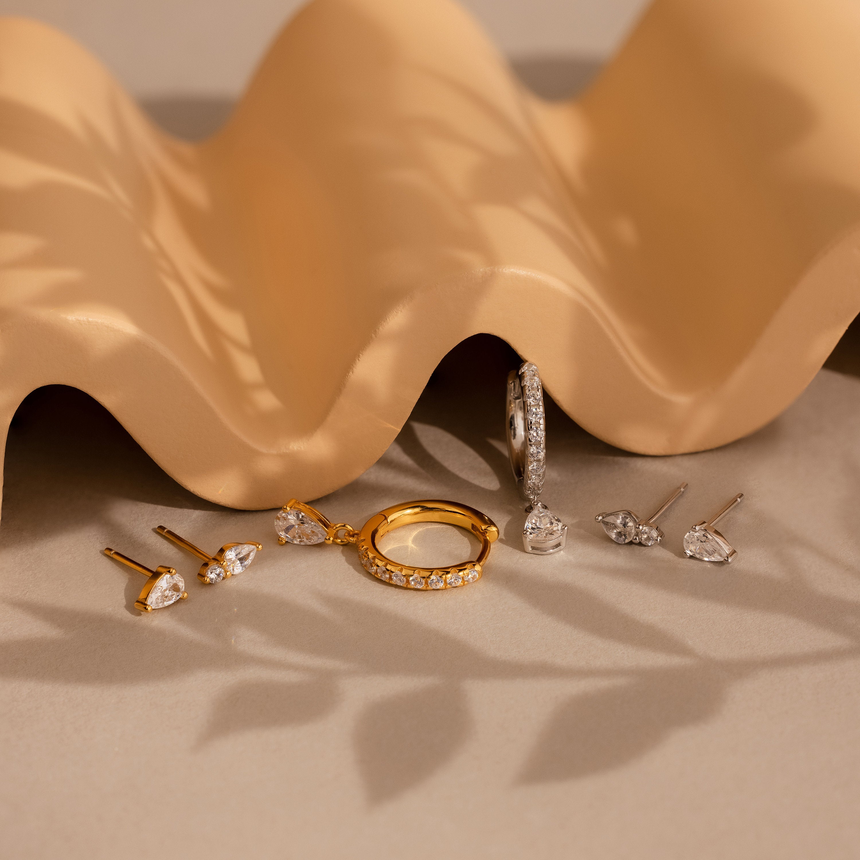 A group of jewelry, including the Diamond Drop Earrings Set, arranged elegantly on a table.