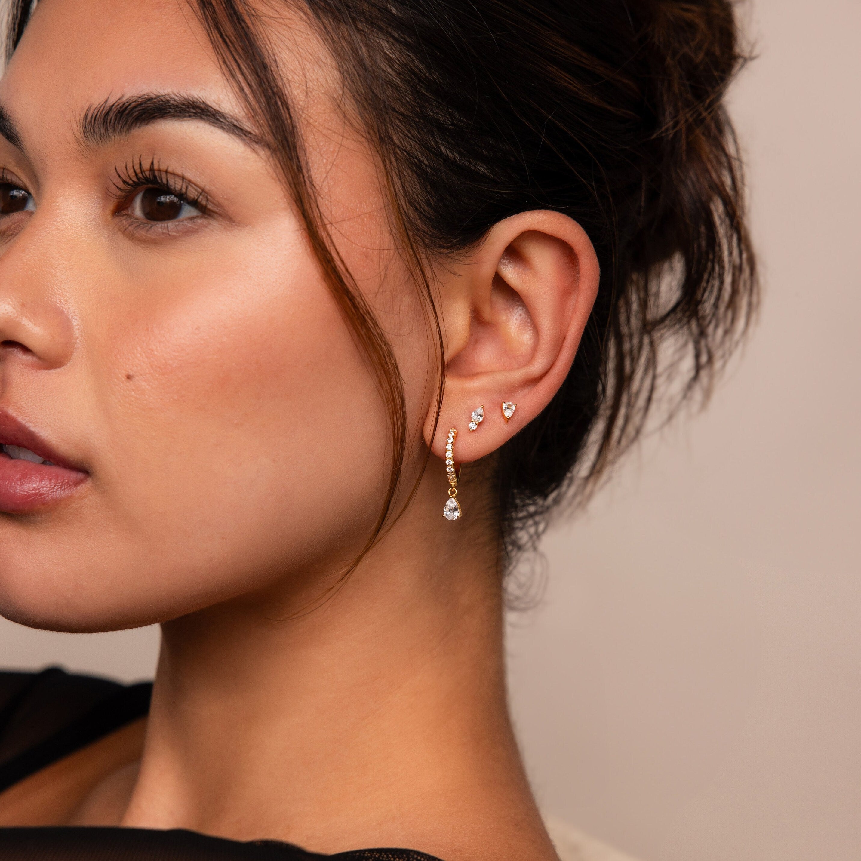 Woman wearing three earrings—two small studs and one from the Diamond Drop Earrings Set—shown in a close-up side profile.