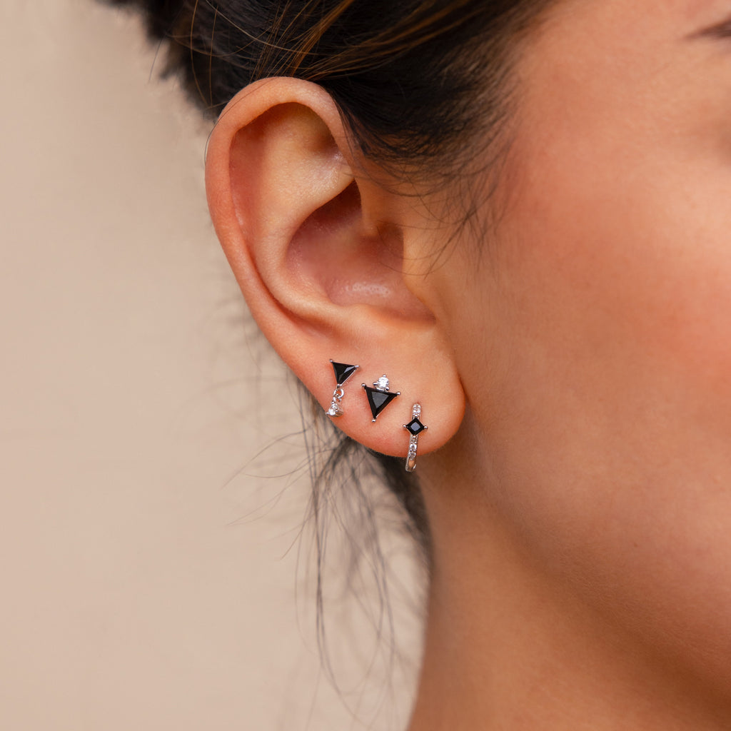Close-up of a woman's ear wearing the Black Art Deco Earrings Set, showcasing sleek black geometric designs and silver accents for a minimalist jewelry look.