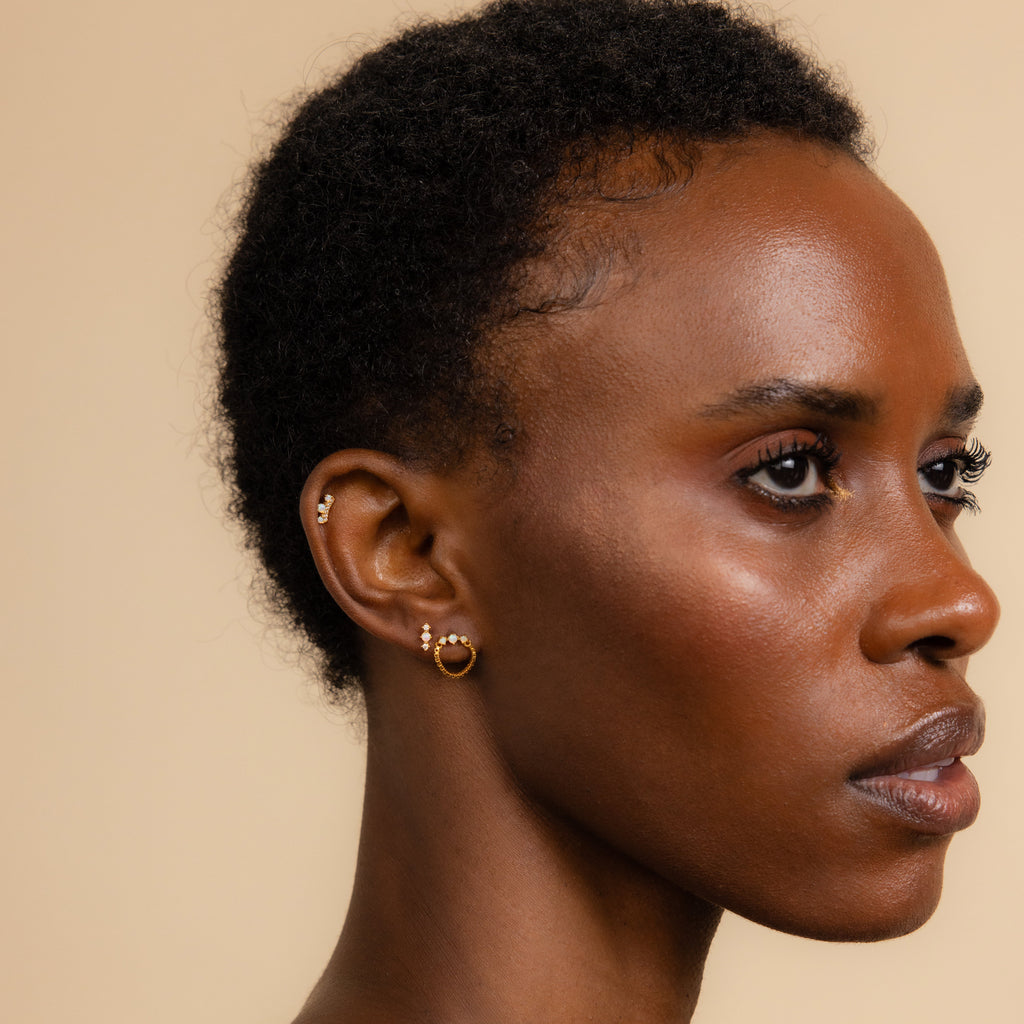 A woman with short hair showcasing elegant Opal Cartilage Studs Set.
