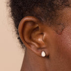 A close-up of a woman's ear wearing Opal Teardrop Studs, highlighting elegant, vintage-inspired jewelry.