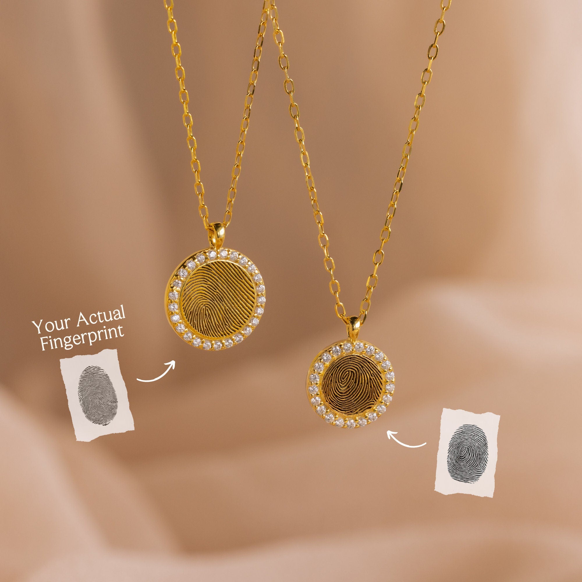 Two Pave Fingerprint Coin Necklaces with custom engraved fingerprint designs are displayed beside matching fingerprint images on a soft beige background—a meaningful memorial gift.
