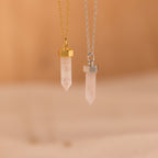 Two Rose Quartz Necklace pendants with gold and silver chains hang gracefully on a soft beige background, highlighting the elegant style of this stone of love.