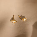 Opal and Diamond Studs, ideal for cartilage or helix piercings, are displayed on light beige satin fabric.