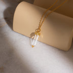 The Clear Quartz Necklace features a hexagonal quartz point pendant on a gold chain, perfect for adding crystal elegance to any jewelry collection.