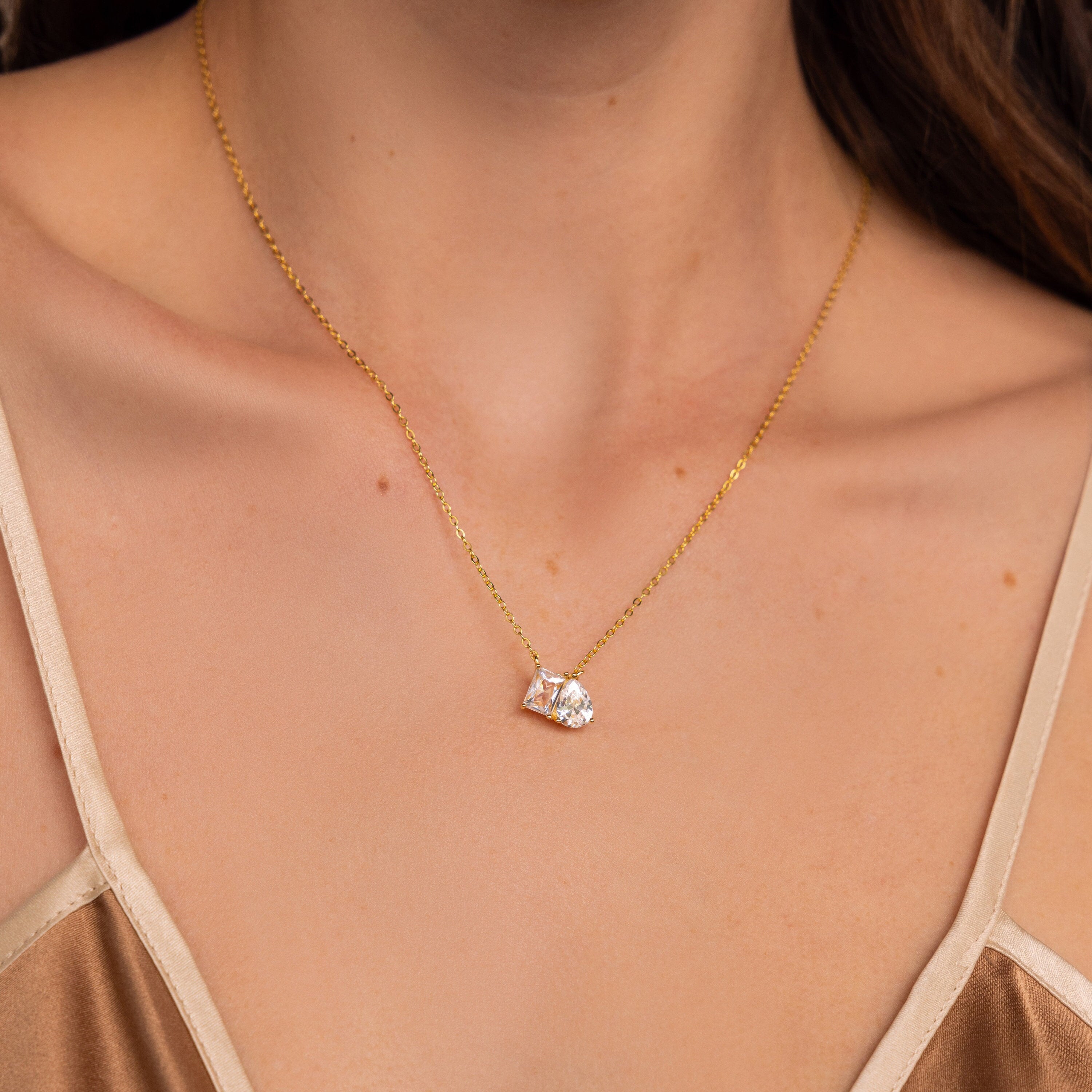 A woman wearing the Toi et Moi Diamond Necklace, featuring a sparkling, heart-shaped pendant and an elegant teardrop-shaped diamond.