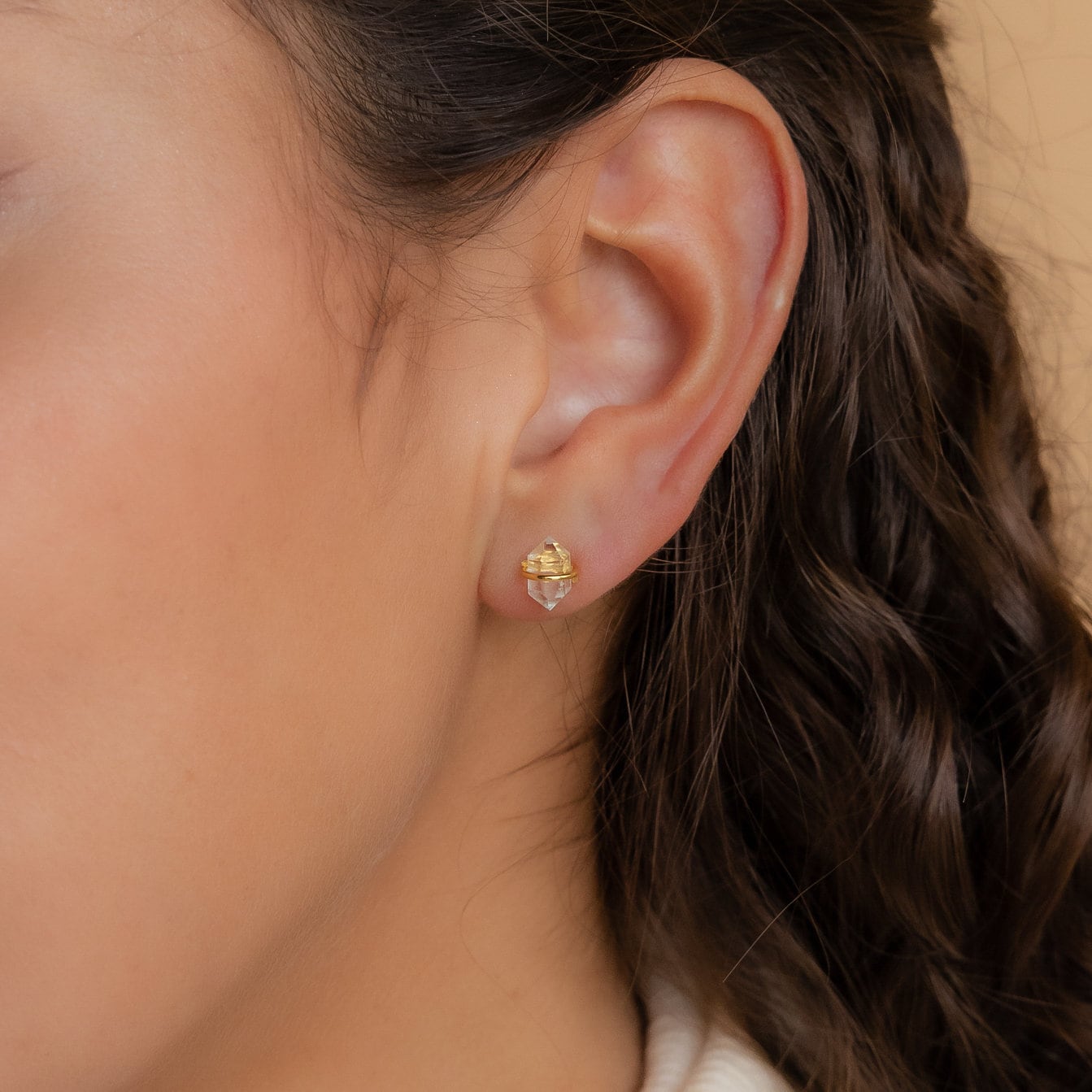 Close-up of a woman's ear wearing Herkimer Diamond Earrings—small gold studs with clear Herkimer diamonds.