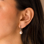 A close-up of a woman's ear wearing Freshwater Pearl Drop Hoops, highlighting their timeless elegance.
