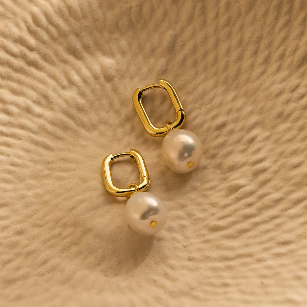 Elevate your style with our Freshwater Pearl Drop Hoops—gold hoops adorned with dangling white pearls, perfect for adding timeless elegance to any outfit.