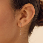 Close-up of a woman's ear wearing Dainty Diamond Drop Earrings—ideal as bridesmaid jewelry or for an elegant wedding look.