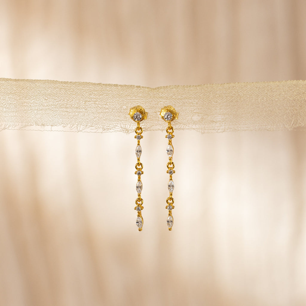 Dainty Diamond Drop Earrings with delicate bead details, ideal for bridesmaids, showcased against a soft beige fabric background.
