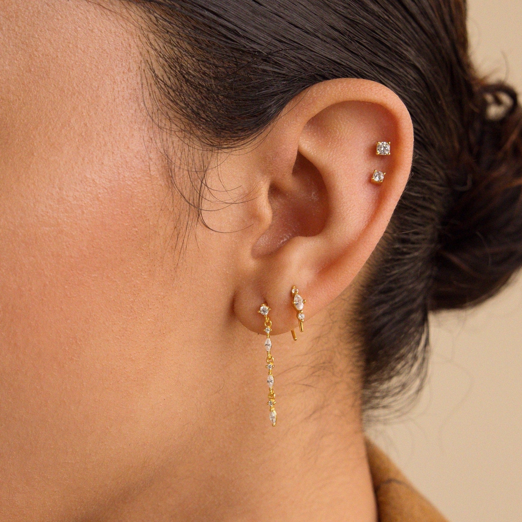 Close-up of a woman's ear wearing Dainty Diamond Drop Earrings—ideal as elegant wedding earrings or perfect bridesmaid jewelry.