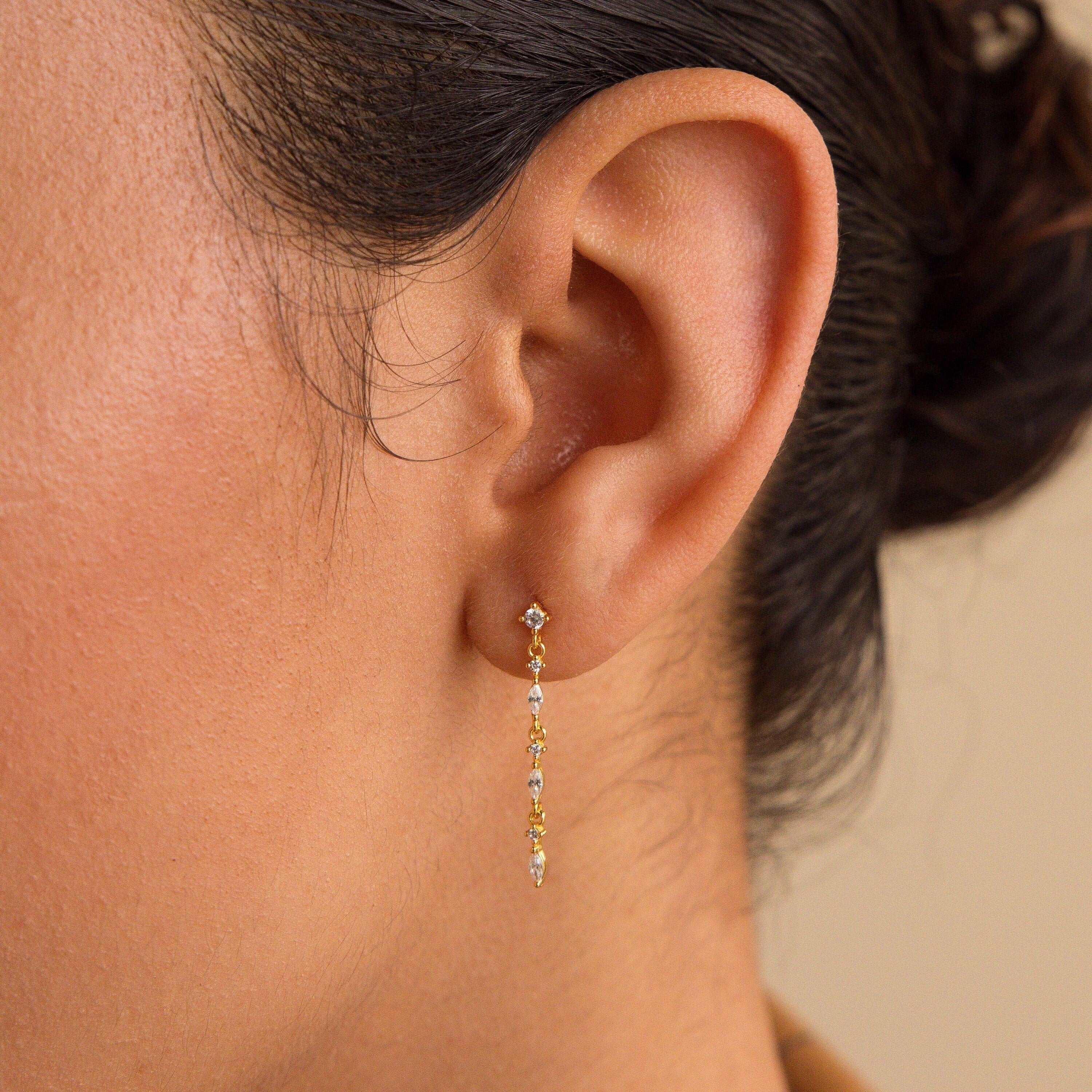A close-up of a woman's ear wearing Dainty Diamond Drop Earrings, ideal as wedding earrings or elegant bridesmaid jewelry.