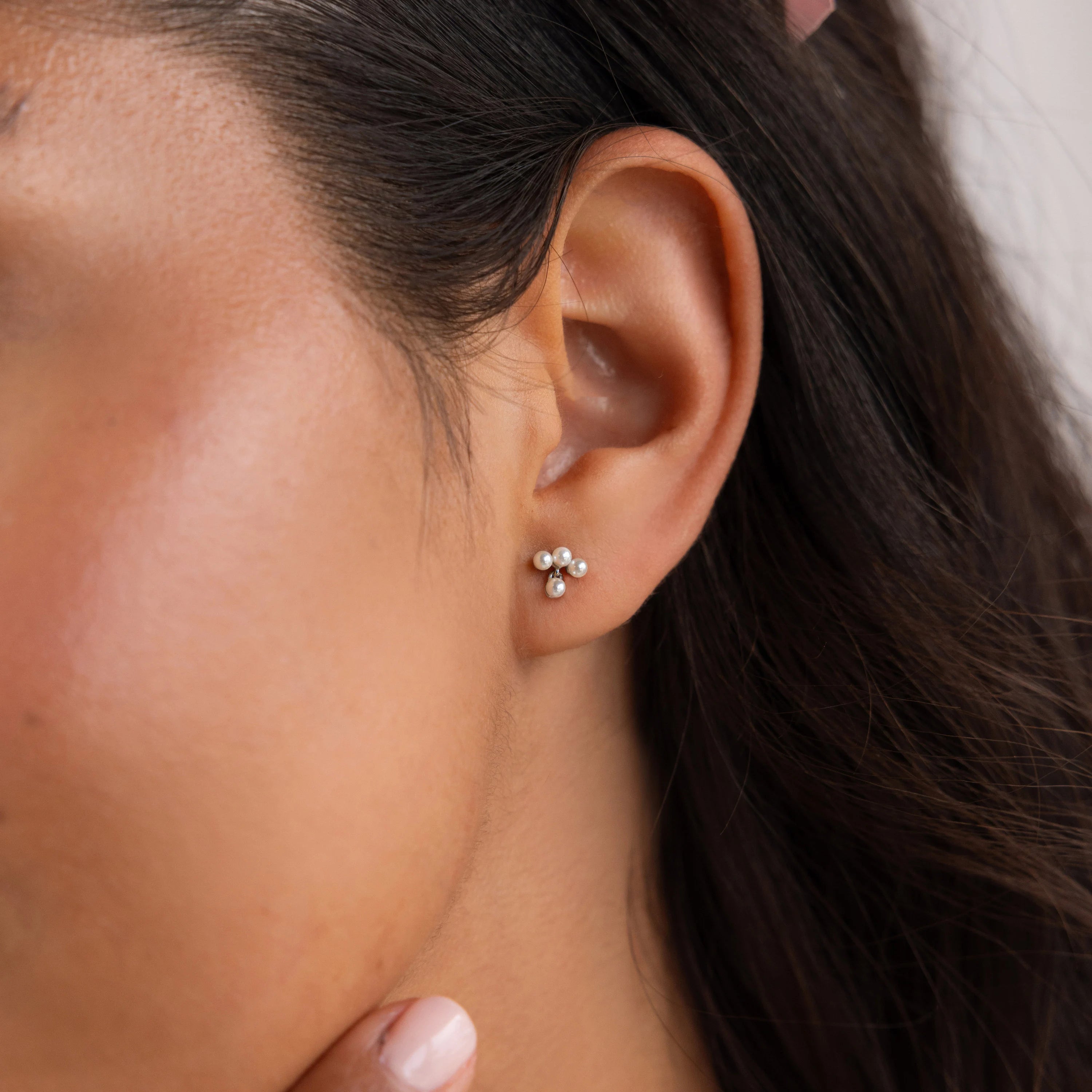 Close-up of a woman's ear wearing Pearl Cluster Drop Studs—small, delicate earrings that make an elegant bridal accessory for weddings.