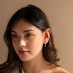 Model wearing Dainty Pearl Huggies in Gold.