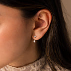 Close-up of a woman’s ear wearing Diamond Pearl Ear Jackets—minimalist earrings featuring a pearl drop with a sparkling diamond accent above it.