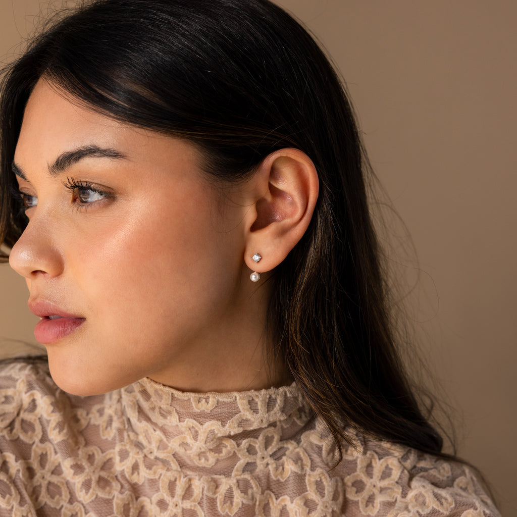 A woman with long dark hair wears the Diamond Pearl Ear Jackets and a beige lace top as she looks to the left.