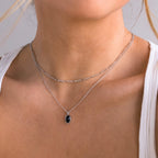 A woman wears the Onyx Figaro Duo Necklace—two silver Figaro chains, one with a bold black onyx pendant—over a white tank top.