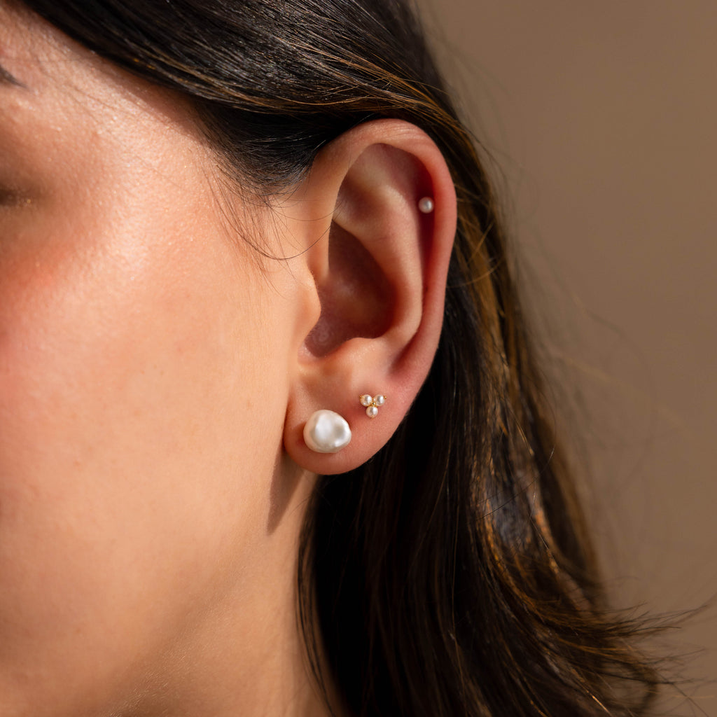 A close-up of a woman's ear adorned with Freshwater Pearl Studs, highlighting their classic elegance.