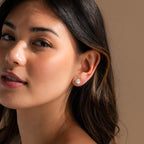 A woman with long hair exudes timeless elegance, highlighted by her exquisite Freshwater Pearl Studs.
