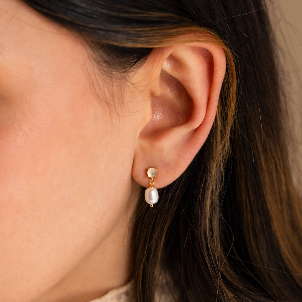Close-up of a woman's ear wearing Moonstone Pearl Drop Earrings, a timeless and elegant addition to any jewelry collection.